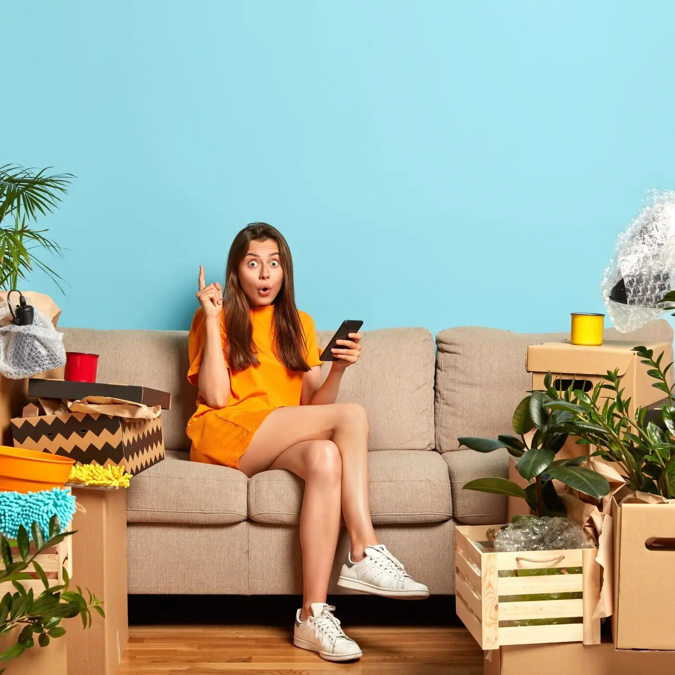 Überraschte Frau hebt den Zeigefinger und bekommt eine ausgezeichnete Idee zur Gestaltung eines Zimmers.