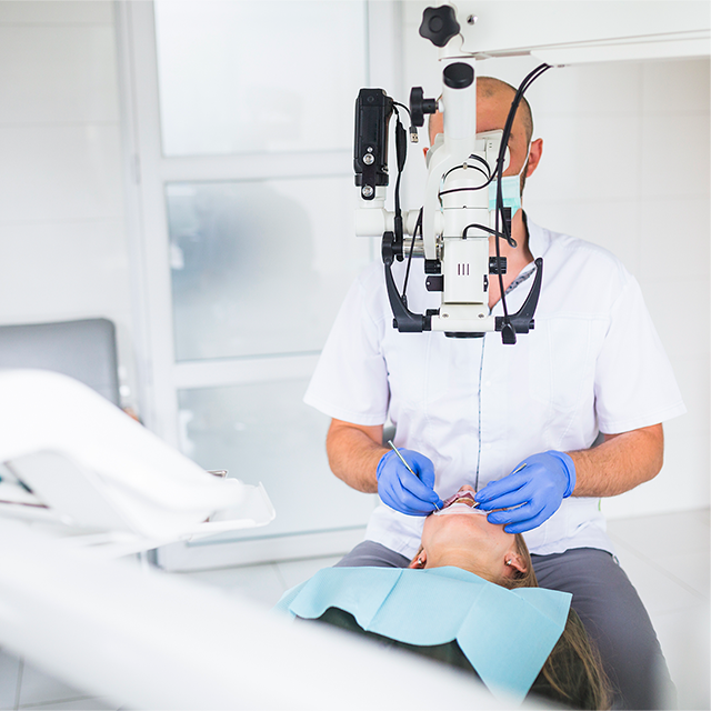 professional-dentist-examining-patient-with-dental-microscope